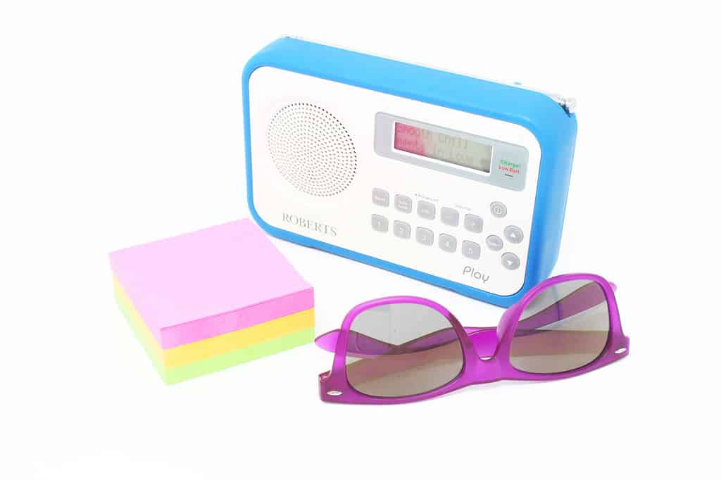 What is Shutter Speed in Photography? Overexposed still life. Blue radio, coloured sticky notes, purple sunglasses.