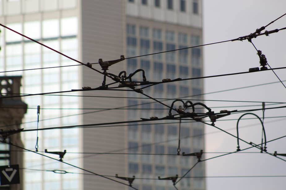 What is Aperture in Photography? Silhouetted web of tram cables against a blurred city background.
