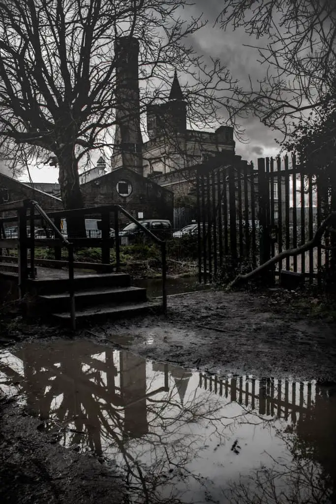 Dark brooding castle reflected in a muddy puddle