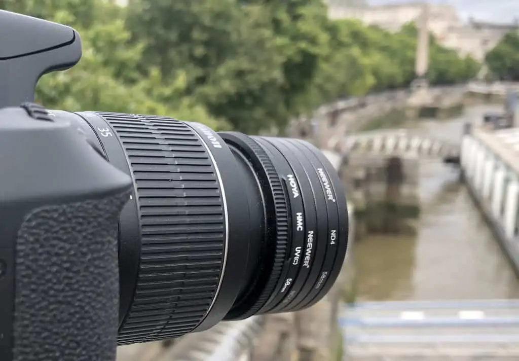 What Are ND Filters in Photography?  Stacked ND filters on a camera lens.