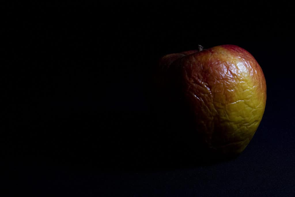How to Take Low Key Photos Indoors And Outdoors! Wrinkled apple in a dark scene.