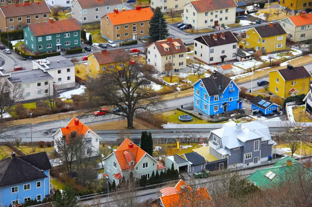 Aerial view of colourful houses spaced out in a suburban landscape.