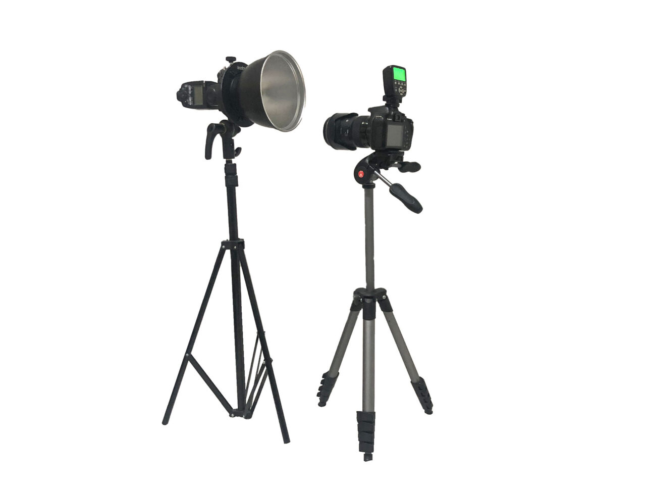 Speedlite with a 7-inch reflector on a stand and a camera on a tripod on a white background