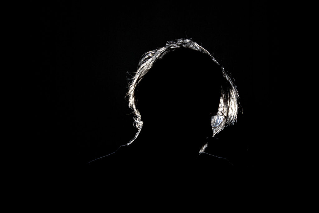 Male subject back lit with single rim light on a black background