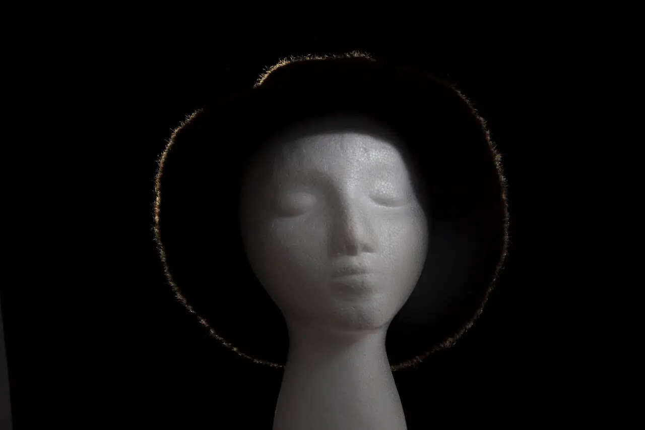 Mannequin head wearing a rim lit fur hat with key and fill lights illuminating the front