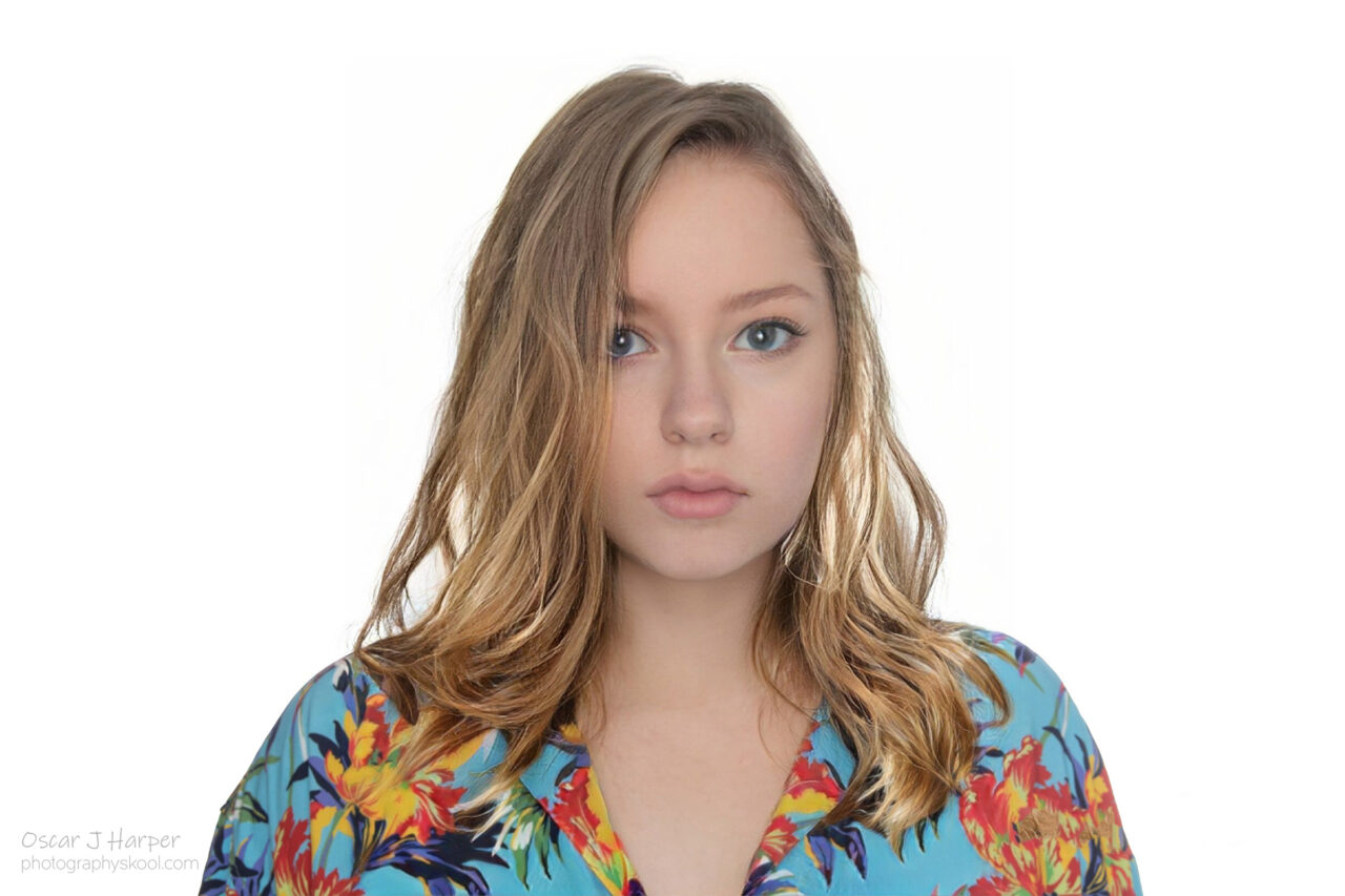 Blond female with long hair wearing a colourful floral blouse lit by shadowless flat studio lighting.